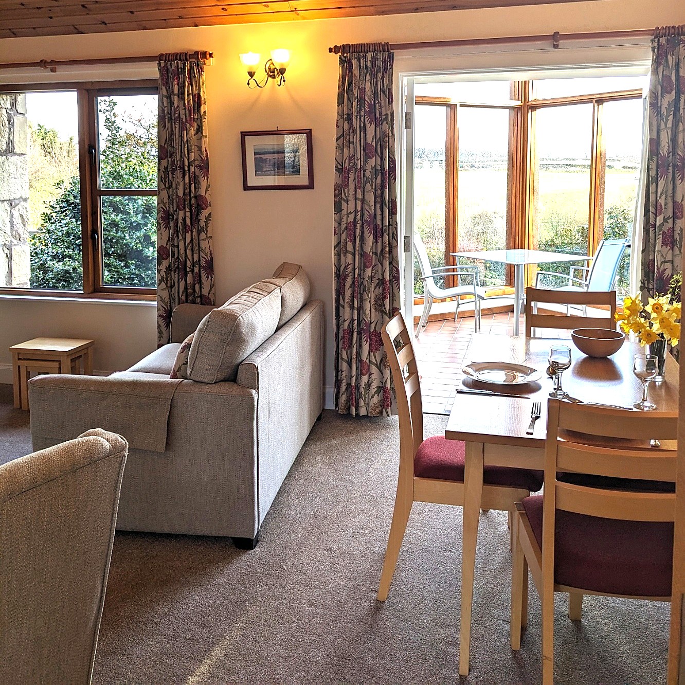 Mungo's Well Cottage living room with dining area, comfy seating level access into conservatory and wonderful views.