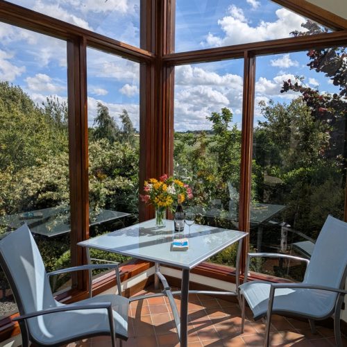 Relax in Thairn Cottage garden room. Admire the beautiful gardens and hills beyond.