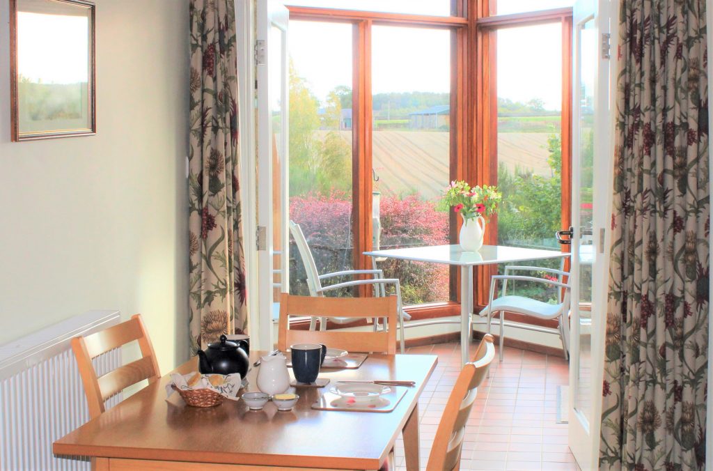 Level access from the dining area in the living room into your south-facing conservatory with amazing views at Begrum cottage Burnbrae Holiday cottages