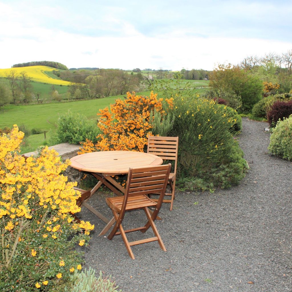 Outside table and chairs with lovely views at our eco holiday cottage in the Scottish Borders